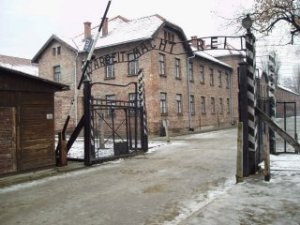 Вход в Освенцим и немецкая надписью на воротах: "Работа освобождает!"